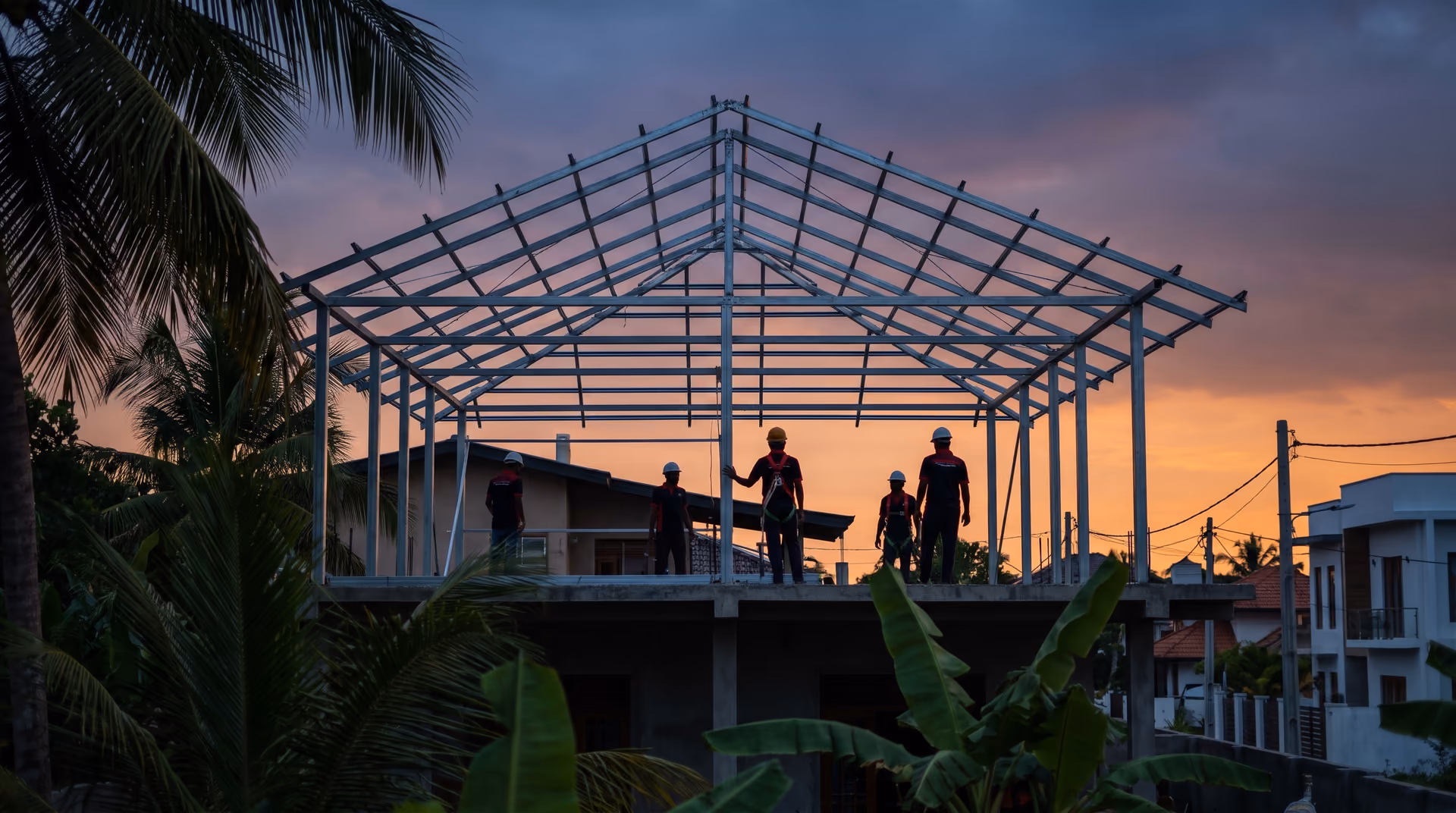 Completed galvanised C purlin roof frame on a Sri Lankan house silhouetted against a dusk sky