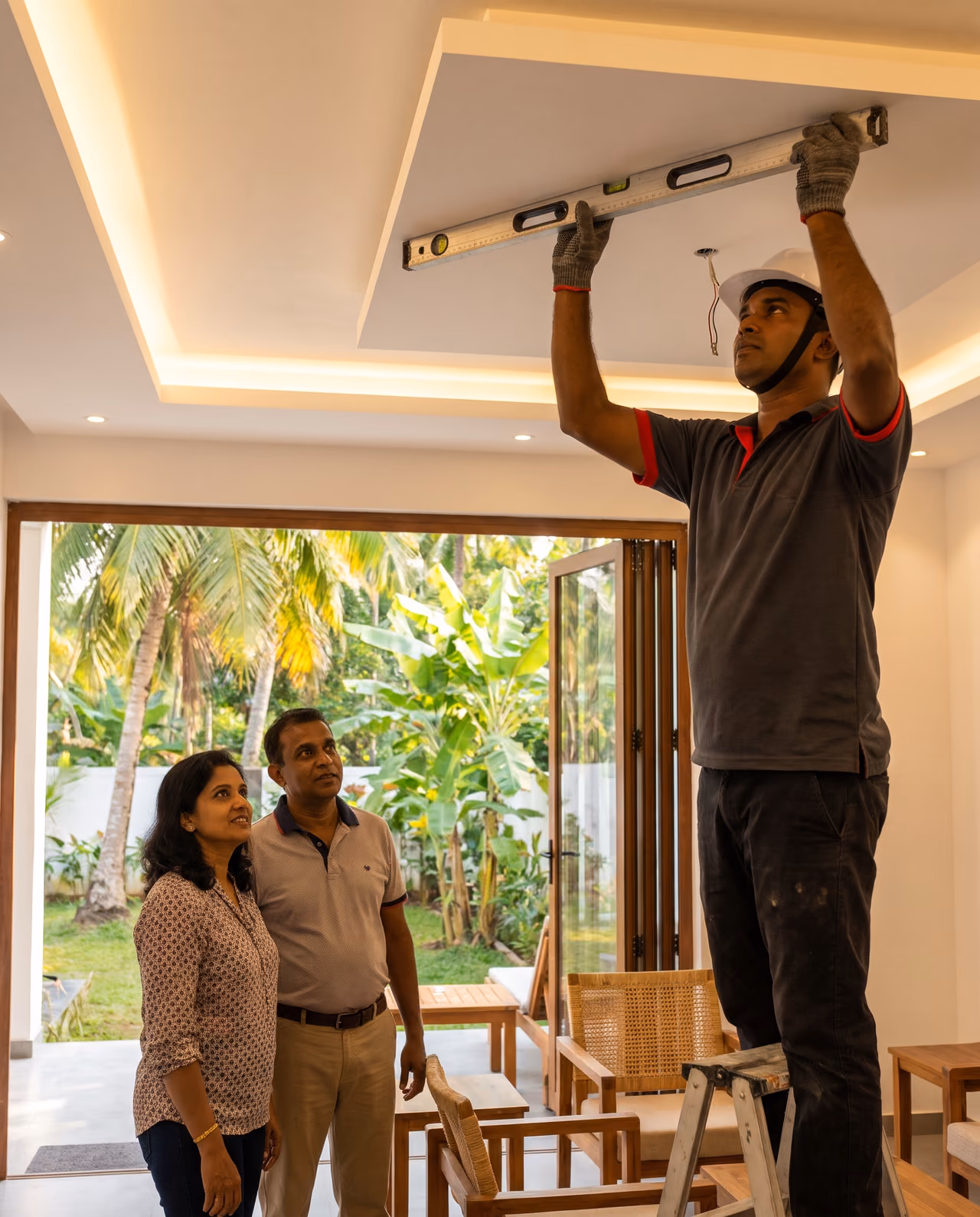 Modern Sri Lankan living room with a white gypsum ceiling, cove lighting and an SHA Roofing technician checking the level